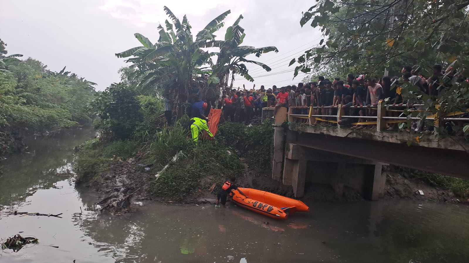Petugas BPBD Jombang saat mengevakuasi remaja tenggelam di sungai Bawangan Ploso. [Dok]